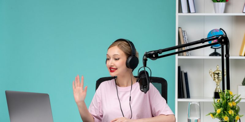 blogger-journalist-blonde-cute-young-girl-recording-video-computer-office-saying-hello